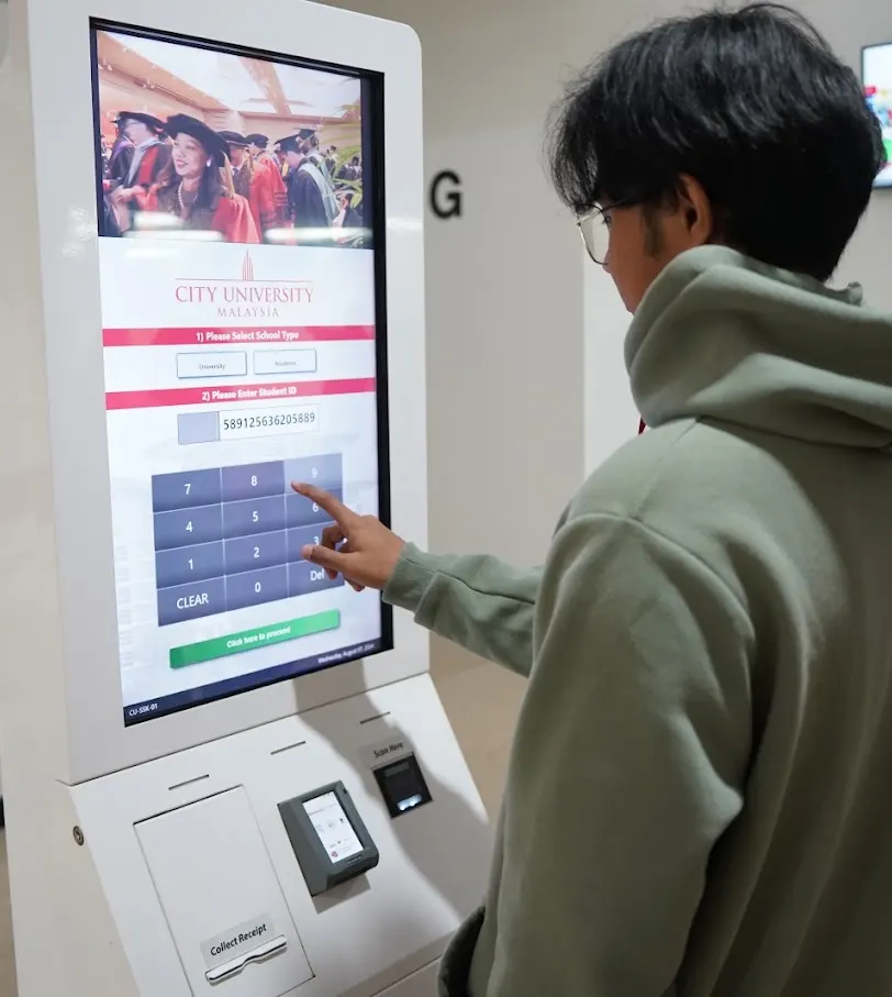 City University Malaysia talabasi kampusdagi o‘z-o‘ziga xizmat terminalidan foydalanmoqda
